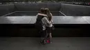 Warga berpelukan di depan The National September 11 Memorial di Lower Manhattan, New York, Kamis (10/9/2015). Masyarakat akan menggelar peringatan terkait tragedi 9/11. (REUTERS / Andrew Kelly)