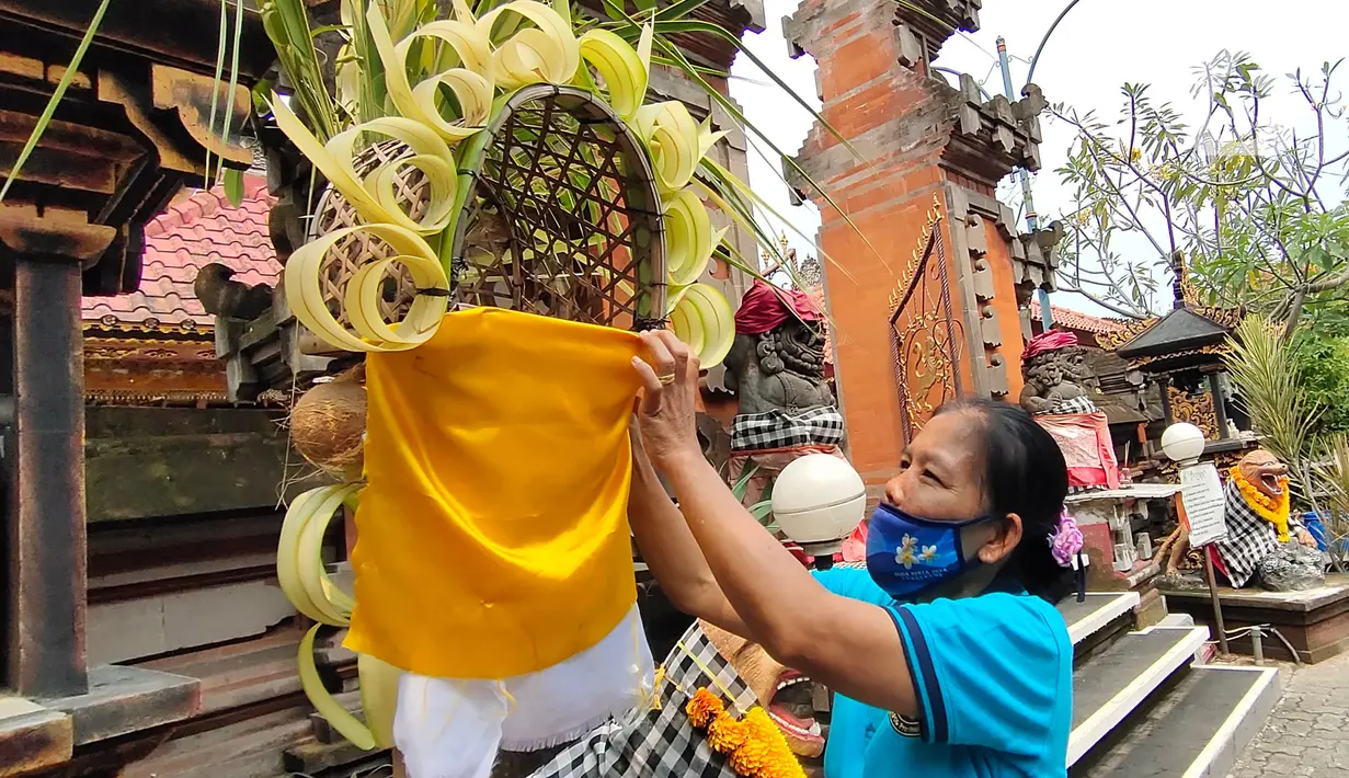 Umat Hindu memasang hiasan di Pura Kerta Jaya, Kota Tangerang, Banten, Selasa (15/9/2020). Persiapan tersebut dilakukan jelang Hari Raya Galungan yang jatuh pada 16 September 2020. (Liputan6.com/Angga Yuniar)