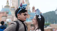 Liburan bareng ke Disneyland Hong Kong, keduanya juga tampil serasi dengan mantel dan headpiece. [Foto: @raynwijaya26]