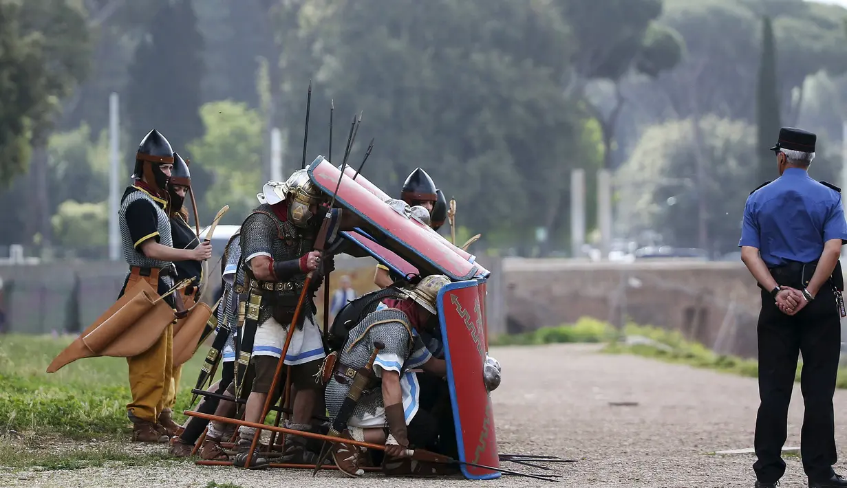 Sejumlah anggota Gruppo Storico Romano (Grup Sejarah Roma) berpakaian perang lengkap dengan tameng dan senjata di Circus Maximus, Roma, Italia , (24/4). Kegiatan ini untuk merayakan ulang tahun berdirinya Roma yang ke-2769. (REUTERS / Alessandro Bianchi)