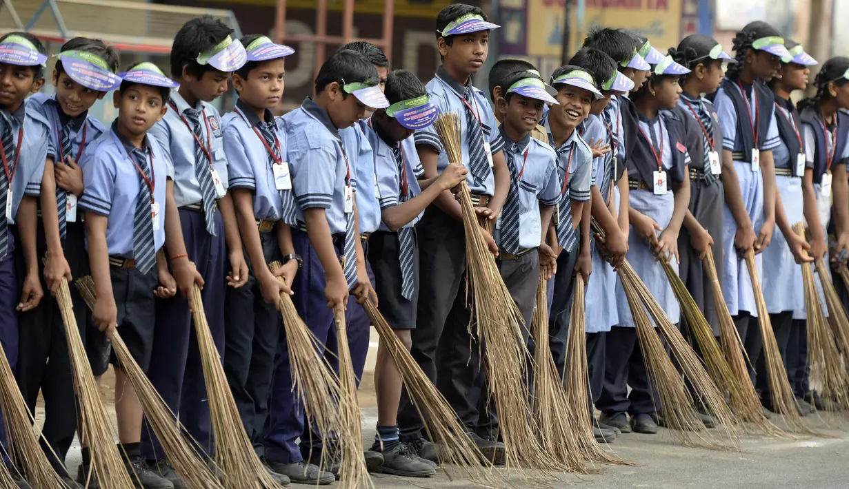 Sejumlah pelajar India membawa sapu saat mengambil bagian dalam 'Swachh Bharat Abhiyan' atau kampanye kebersihan di Hyderabad (12/2). Kampanye ini bertujuan untuk membersihkan jalanan dan infrastruktur di kota-kota India. (AFP Photo/Noah Seelam)