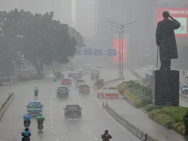 Sejumlah kendaraan melintas di tengah hujan lebat di kawasan Jalan Sudirman, Jakarta, Selasa (29/6/2021). BMKG mengungkapkan wilayah Jakarta dan sekitarnya masih dilanda hujan dan hawa dingin di musim kemarau. (Liputan6.com/Faizal Fanani)