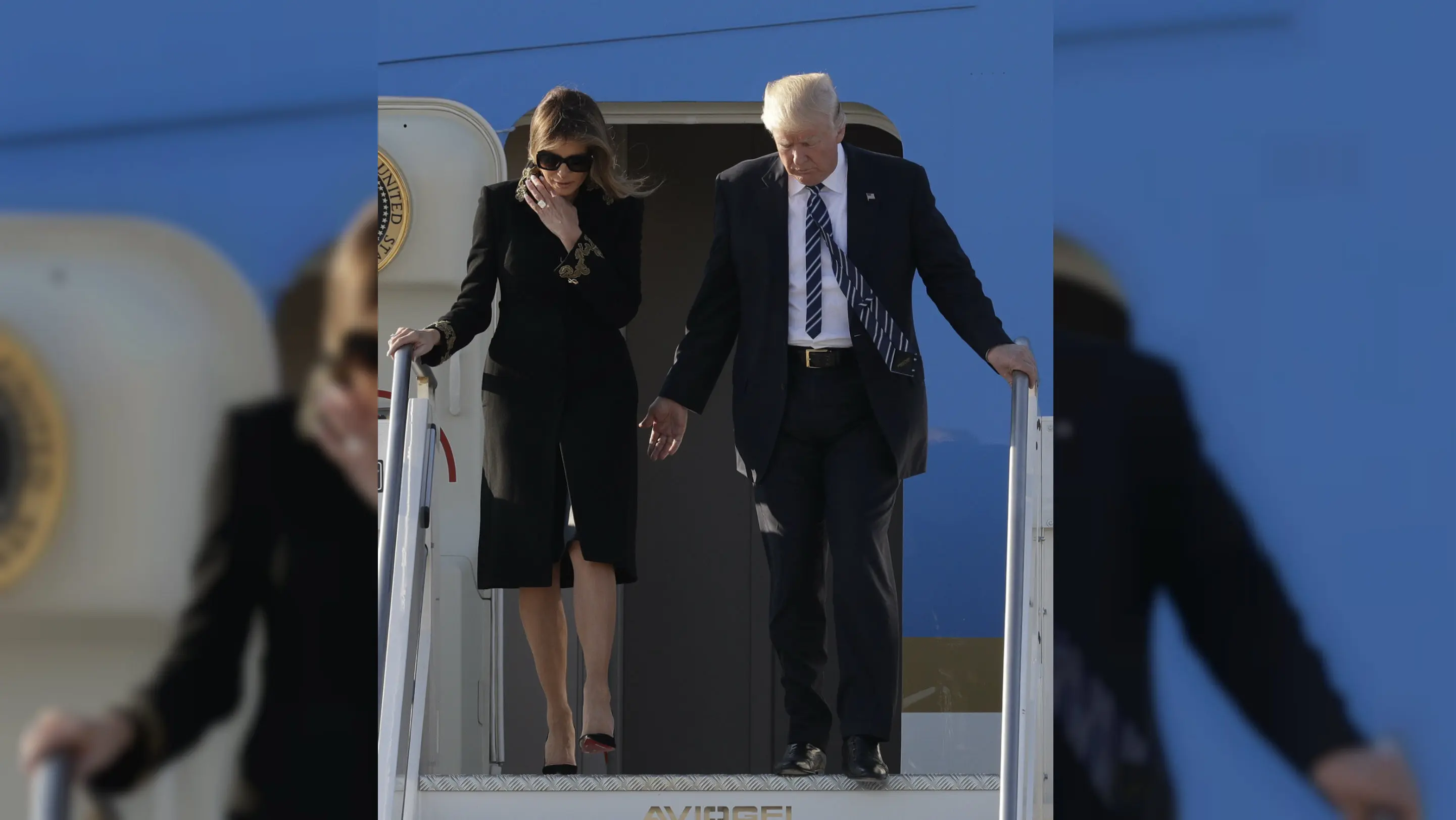 Saat Donald Trump mengulurkan tangannya, Melania justru merapikan rambutnya (AP Photo/Andrew Medichini)