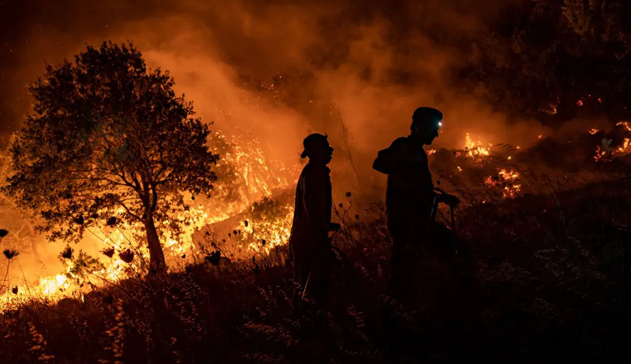 Warga mencoba memadamkan api yang menyebar di Desa Akcayaka, Milas, Provinsi Mugla, Turki, Jumat (6/8/2021). Warga ikut berjuang melawan kebakaran hutan paling mematikan dalam beberapa dekade di Turki. (Yasin AKGUL/AFP)