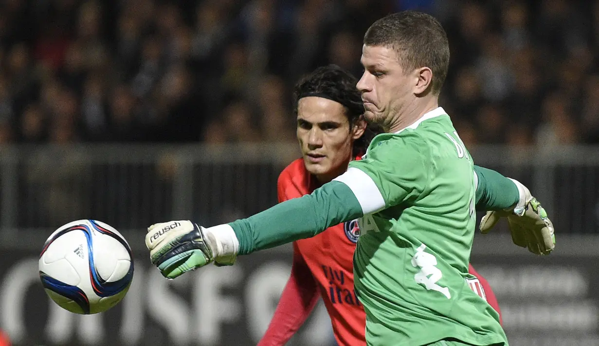 Kiper Angers, Ludovic Butelle (kanan) berebut bola dengan pemain Paris Saint-Germain, Edinson Cavani pada lanjutan Ligue 1 di Stadion Jean Bouin, Angers, France. (AFP Photo/Damien Meyer)