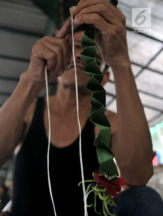 Pedagang saat membuat hiasan kembang makam di salah satu kios Pasar Rawa Belong, Jakarta, Senin (29/4). Pedagang kembang makam di Pasar Rawa Belong mengaku dapat mengantongi omzet hingga Rp 500 ribu per hari. (merdeka.com/Iqbal Nugroho)