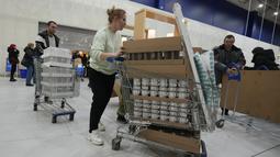 Orang-orang membawa pembelian mereka saat toko IKEA tutup di pinggiran St. Petersburg, Kamis (3/3/2022). Peritel IKEA menghentikan operasional di "Negeri Beruang Merah" dan Belarusia untuk sementara waktu mulai Jumat, 4 Maret 2022 buntut dari invasi Rusia ke Ukraina. (AP Photo/Dmitri Lovetsky)