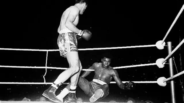 Muhammad Ali terjengkang usai dihantam hook kiri Henry Cooper saat keduanya naik ring 1963 lalu. 