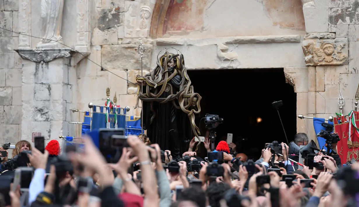 Sebuah patung Saint Domenico dikerumuni ular saat prosesi tahunan di Cocullo di Italia (1/5). Setiap tahun di bulan Mei, sejumlah ular ditempatkan di patung St. Domenico dalam prosesi di sekitar kota (AFP/Tiziana Fabi)