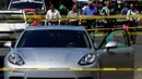 Petugas berjaga di lokasi penembakan mobil sport Porsche oleh orang tidak dikenal di Guadalajara, Meksiko, (14/3). Meksiko banyak mengalami kekerasan terkait dengan perdagangan narkoba. (AFP Photo/Ulises Ruiz)