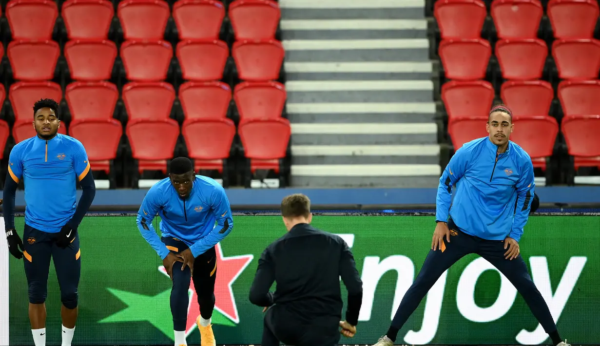 Gelandang RB Leipzig Christopher Nkunku (kiri) dan penyerang Yussuf Poulsen melakukan pemanasan saat mengikuti sesi latihan di stadion Parc des Princes di Paris (23/11/2020). Leipzig akan bertanding melawan PSG pada Grup H Liga Champions. (AFP/Franck Fife)
