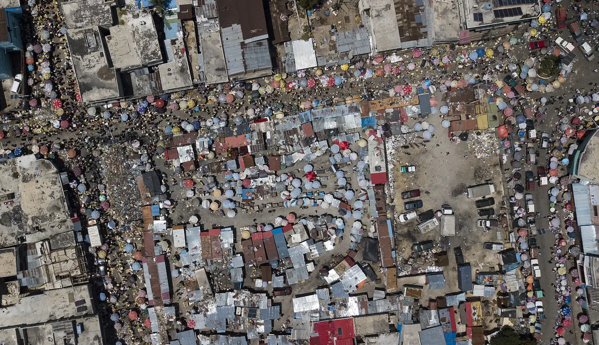 Orang-orang berbelanja di pasar Petion-Ville di Port-au-Prince, empat hari setelah pembunuhan Presiden Haiti Jovenel Moise, Minggu (11/7/2021). Sebelumnya, Presiden Haiti Jovenel Moise tewas dibunuh dalam serangan di kediaman pribadinya, pada Rabu 7 Juli 2021 dini hari. (AP Photo/Matias Delacroix)