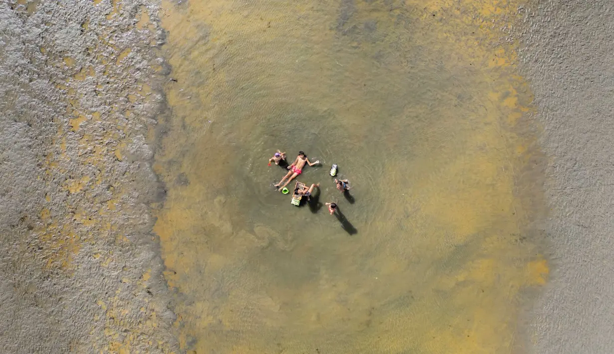 Foto udara orang-orang yang berada di bawah sinar matahari di sebuah pantai di Puerto Madryn, provinsi Chubut, Argentina pada tanggal 26 Januari 2024. (MAXI JONAS/AFP)