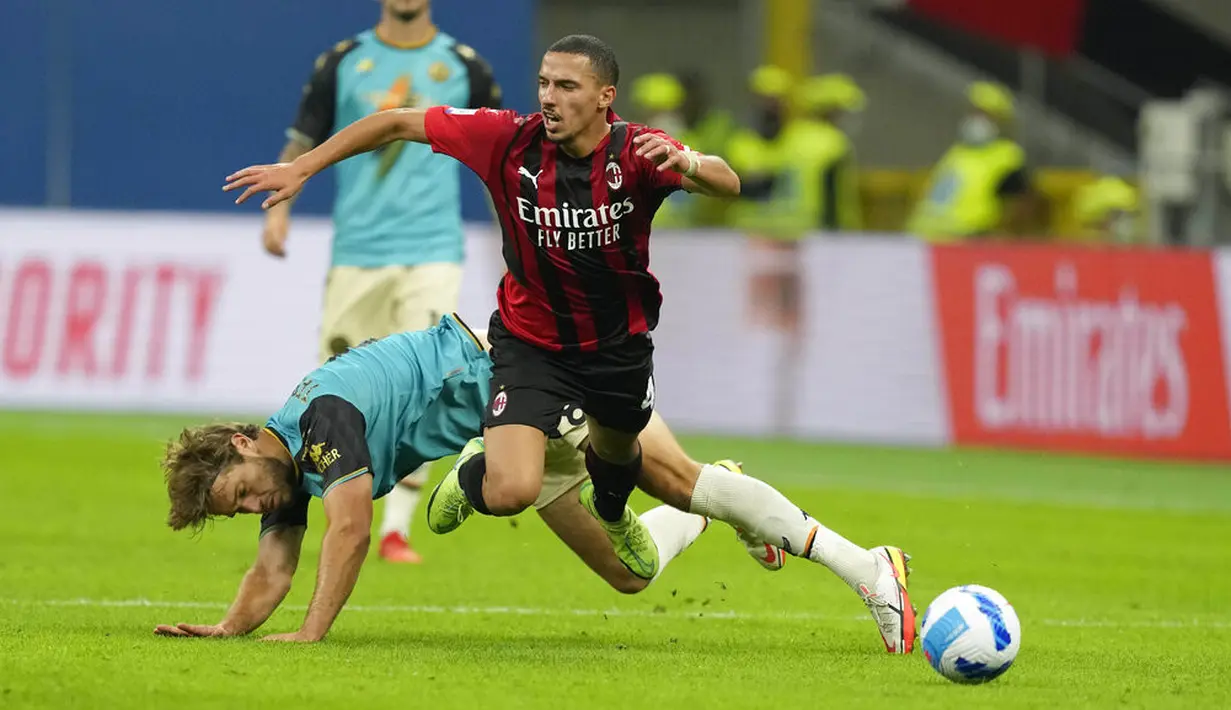Gelandang AC Milan, Ismael Bennacer berebut bola dengan gelandang Venezia Tanner Tessmann pada laga pekan ke-5 Serie A 2021/22 di San Siro, Kamis (23/9/2021) dini hari WIB. AC Milan menaklukkan tamunya Venezia dengan skor 2-0. (AP Photo/Antonio Calanni)