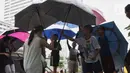 Sejumlah anak-anak menawarkan jasa ojek payung kepada warga di kawasan Bundaran HI, Jakarta, Senin (3/2/2020). Hujan deras yang mengguyur sejumlah wilayah di DKI Jakarta dimanfaatkan para pengojek payung untuk mencari penghasilan tambahan. (Liputan6.com/Angga Yuniar)