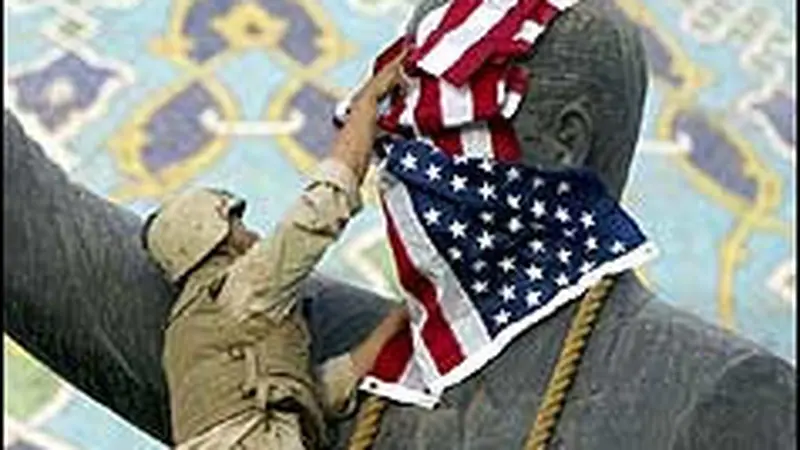 Tentara AS meletakkan bendera pada patung Saddam Hussein di Irak. (AP)