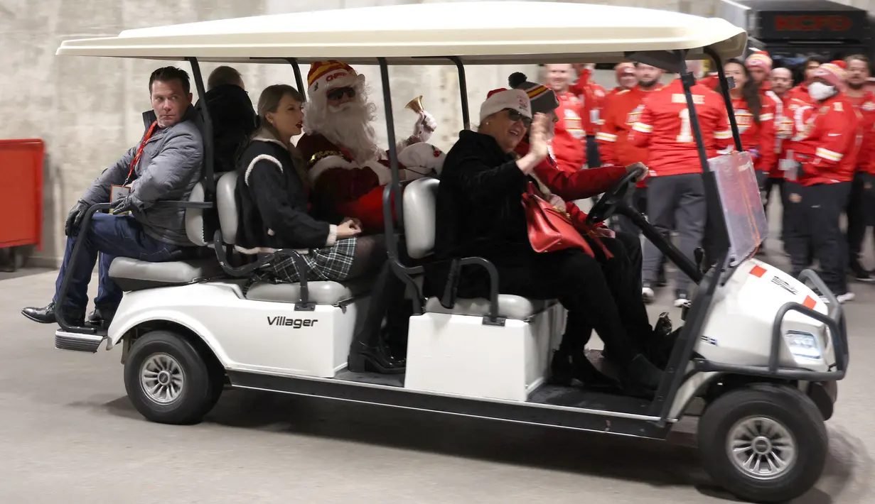 Taylor Swift (ketiga kiri) bersama sejumlah anggota keluarganya menaiki mobil golf atau buggy saat pertandingan NFL (National Football League) antara Kansas City Chiefs melawan Las Vegas Raiders di Arrowhead Stadium, Kansas, Amerika Serikat, Selasa (26/12/2023) WIB. (AFP/Jamie Squire)