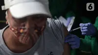 Tenaga kesehatan menyuntikkan vaksin COVID-19 dosis ketiga kepada warga di Puskesmas Kecamatan Kramat Jati, Jakarta, Rabu (12/1/2022). Program vaksinasi lanjutan (booster) COVID-19 diberikan kepada kelompok prioritas yaitu lanjut usia dan penderita immunokompromais. (Liputan6.com/Faizal Fanani)