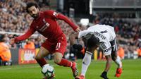 Pemain Liverpool Mohamed Salah (kiri) melewati pemain Fulham Neeskens Kebano pada laga pekan ke-31 Liga Inggris di Stadion Craven Cottage, London, Minggu (17/3). Liverpool menang tipis 2-1. (AP Photo/Kirsty Wigglesworth)