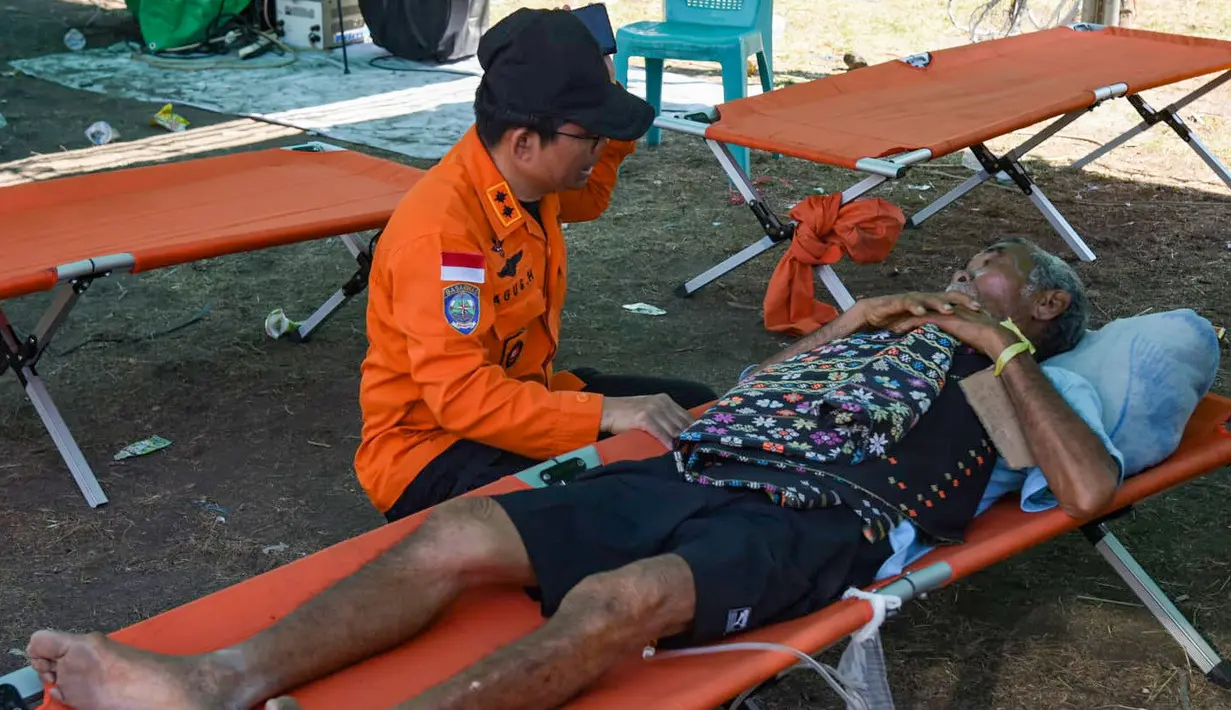Sorang pasien korban gempa NTT mendapatkan perawatan sembari menunggu evakuasi menggunakan helikopter di Lamba Leda Utara, Nusa Tenggara Timur, Selasa, 18 Agustus 2026. (Basarnas)