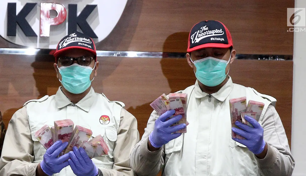 Penyidik KPK menunjukkan barang bukti uang Rp 100 Juta dari OTT Bupati Purbalingga di Gedung Merah Putih KPK, Kuningan, Jakarta, Selasa (5/6). Uang tersebut diduga dari pemenang proyek pembangunan Purbalingga Islamic Center. (Liputan6.com/Herman Zakharia)