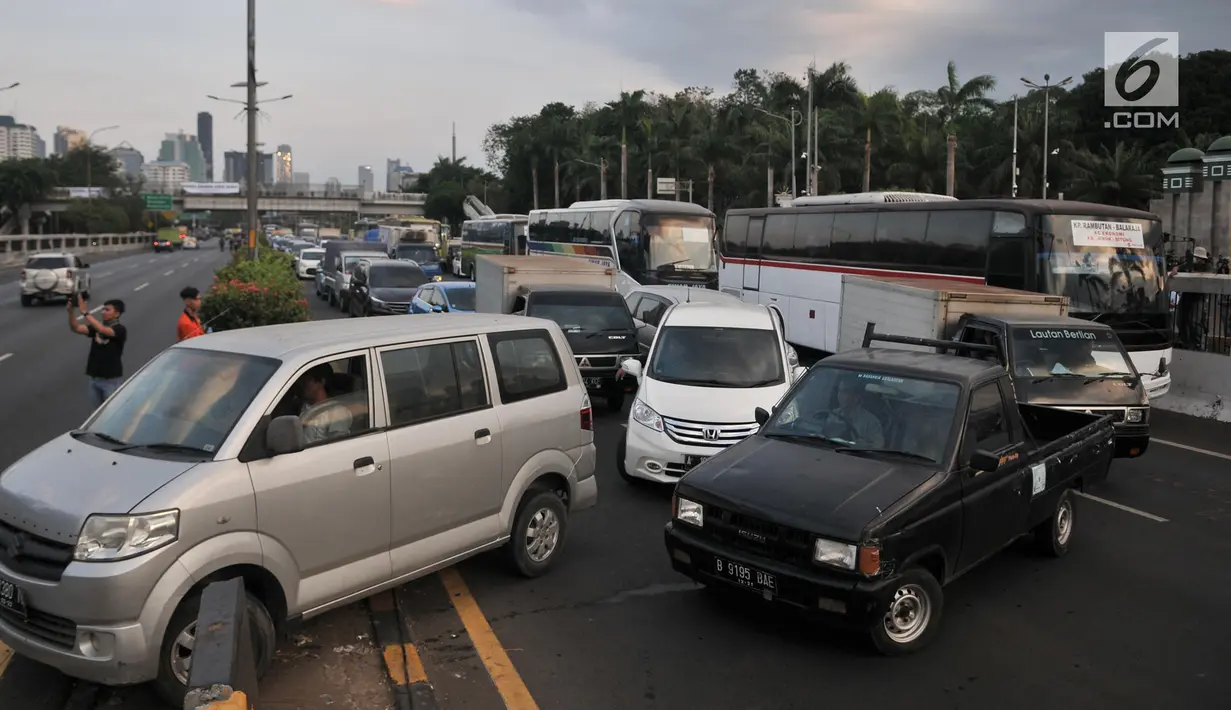 Sejumlah kendaraan memutar balik setelah massa memblokade  Tol Dalam Kota dekat Gedung DPR,  Jakarta, Senin (30/9/2019). Kendaraan yang melintasi terjebak bentrokan antara massa dan polisi yang terjadi di dua sisi sehingga terpaksa berputar arah. (merdeka.com/Iqbal S Nugroho)
