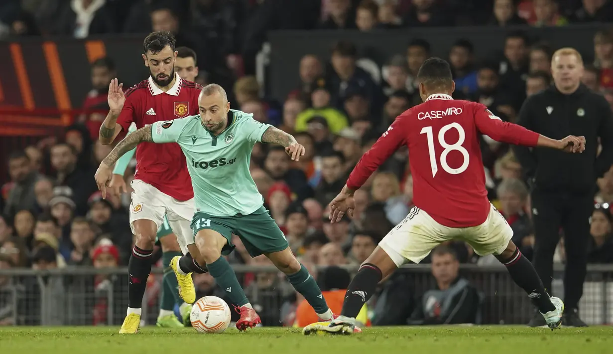Penyerang Omonia Nicosia, Fotis Papoulis dari Omonia berlari dengan bola masuk dari gelandang Manchester United atau MU, Bruno Fernandes pada laga matchday 4 fase grup Liga Europa 2022/2023 di Old Trafford, Jumat dini hari WIB (14/10/2022). Pemain-pemain pengganti MU krusial di dalam kemenangan ini. (AP Photo/Dave Thompson)
