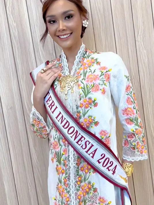 Perempuan kelahiran 2003 inipun memesona mengenakan kebaya panjang putih dengan aksen motif bunga warna warni. Dipadukan bros keemasannya. [@harashtata]