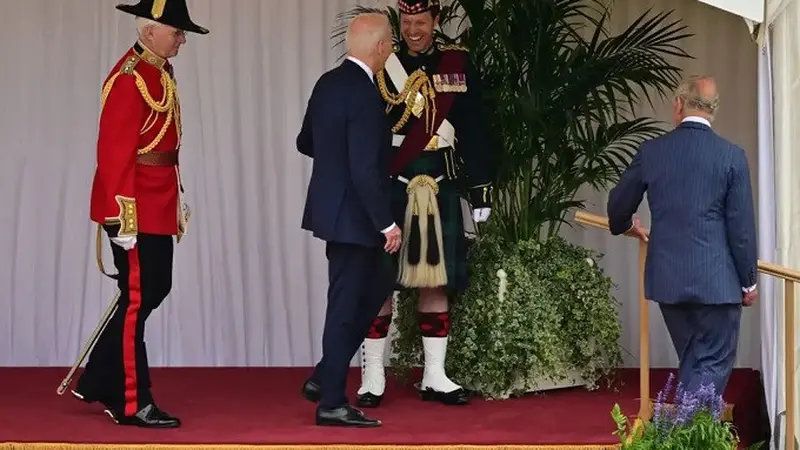 Pengawal tampan Raja Charles III sedang berinteraksi dengan Presiden Amerika Serikat Joe Biden di Kastil Windsor, Inggris, Senin (10/7/2023). (Dok. Ben Stansall/Pool/AFP)