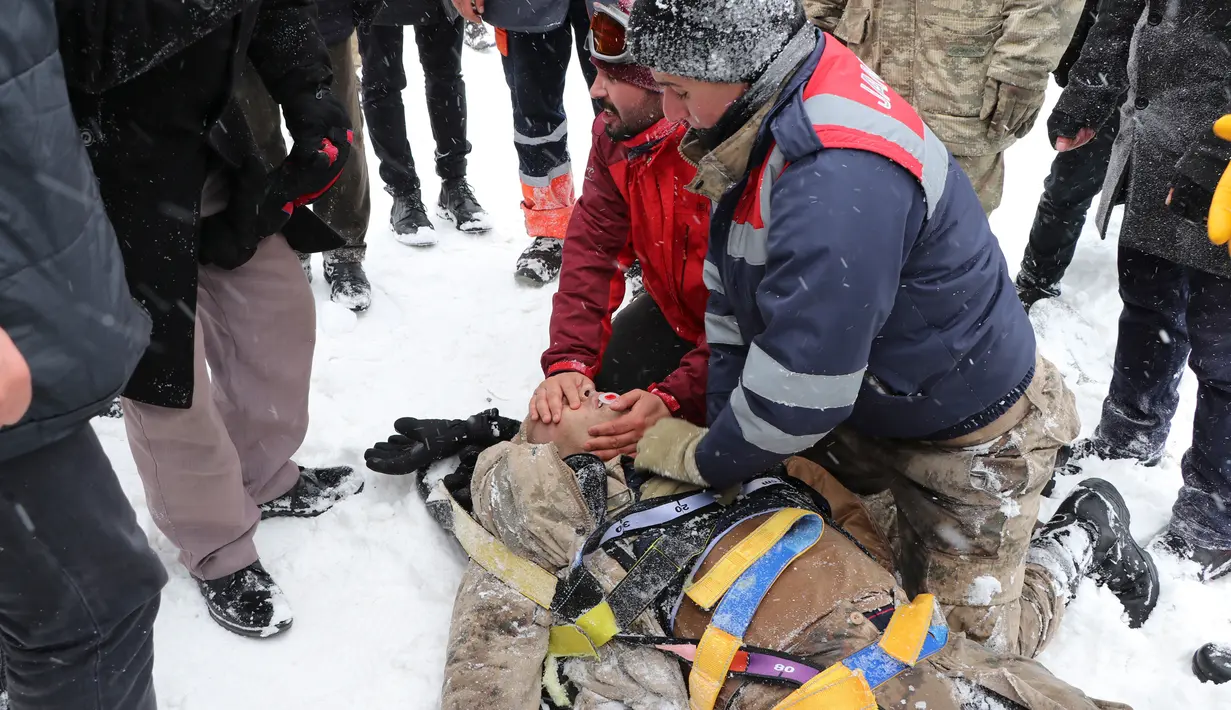 Tim penyelamat memberikan pertolongan pertama kepada korban salju longsor di Bahcesehir, Provinsi Van, Turki, Rabu (5/2/2020). Puluhan personel penyelamat Turki hilang dihantam salju longsor saat mencari korban salju longsor yang terjadi sehari sebelumnya. (Feyat Erdemir/DHA via AP)
