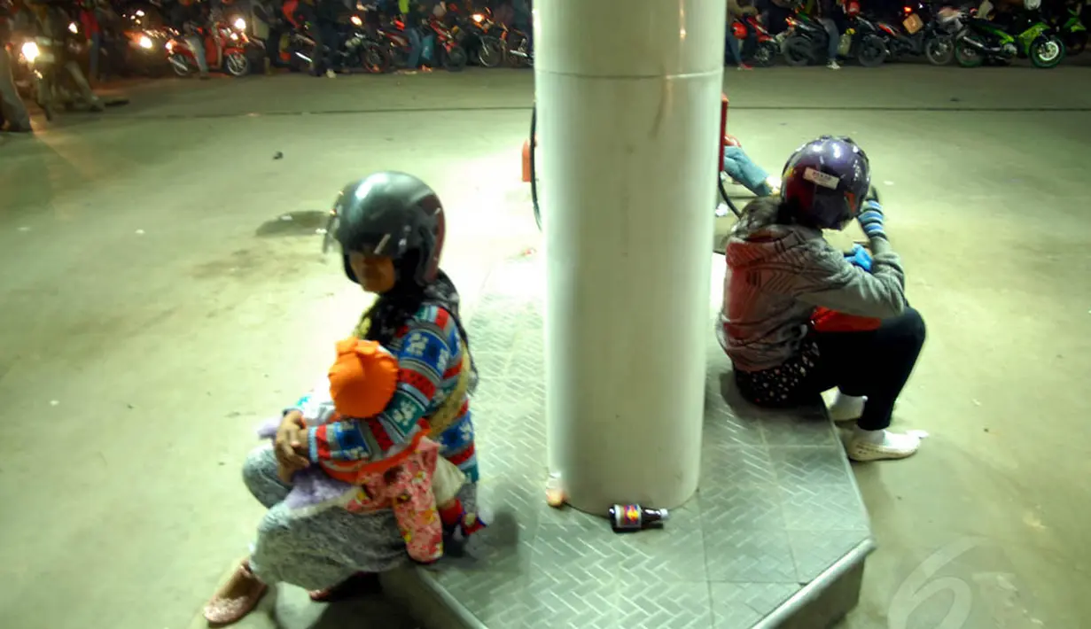 Beberapa pemudik wanita terlihat duduk sembari menunggu antrean yang cukup panjang di salah satu pom bensin kawasan Karawang, Jumat (25/7/14). (Liputan6.com/Miftahul Hayat)