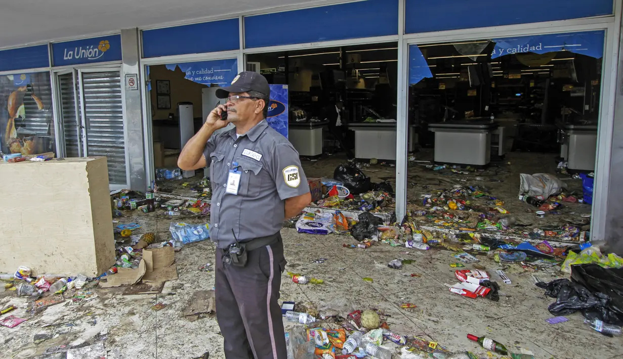 Petugas keamanan berjaga di sebuah toko setelah penjarahan di Managua, Nikaragua, Minggu (22/4). (INTI OCON / AFP)