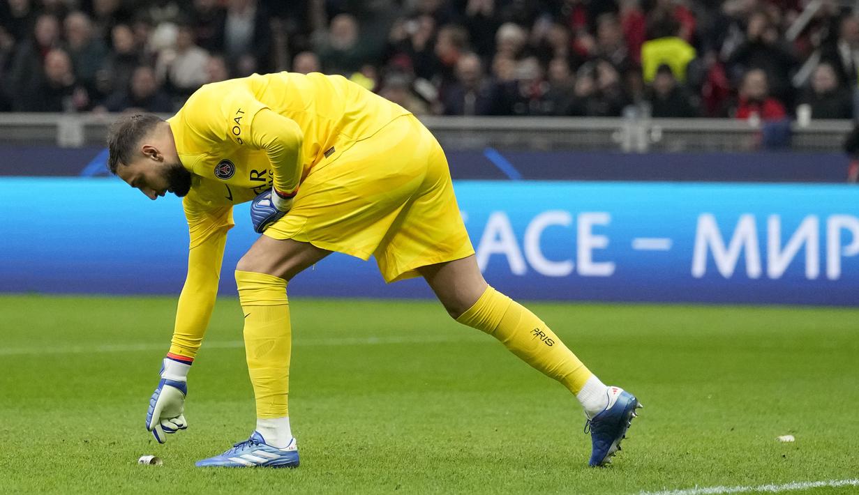Penjaga gawang PSG, Gianluigi Donnarumma, mengambil uang palsu bergambar dirinya untuk disingkirikan dalam laga matchday 4 Liga Champions 2023/2024 yang berlangsung di San Siro, Milan, Rabu (8/11/2023) dini hari WIB. Uang palsu tersebut dilempar oleh Ultras Milan sebagai bentuk kekecewaan kepada Donnarumma yang pindah ke PSG karena tawaran yang menggiurkan. (AP Photo/Antonio Calanni)