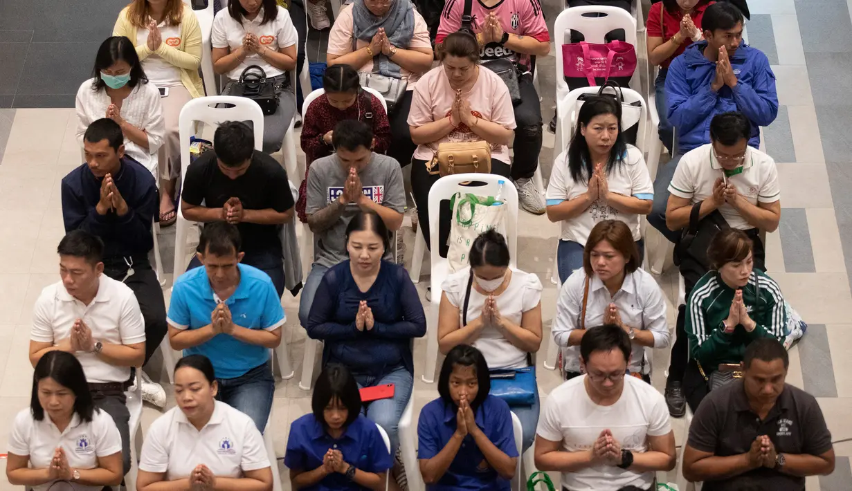 Orang-orang berdoa saat upacara pembukaan kembali pusat perbelanjaan Terminal 21 usai penembakan massal di Nakhon Ratchasima, Thailand, Kamis (13/2/2020). Sebelumnya, seorang tentara yang mengamuk melepaskan tembakan di mal tersebut hingga menewaskan 29 orang. (AP Photo/Sakchai Lalit)