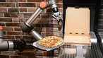 Foto yang diambil pada 1 Juli 2021 menunjukkan "Pazzi", robot pembuat pizza yang sedang bekerja di sebuah restoran di Paris. Robot pembuat pizza dari startup Paris Pazzi tersebut mulai beroperasi di jantung kota Paris pada 5 Juli 2021 (BERTRAND GUAY/AFP)