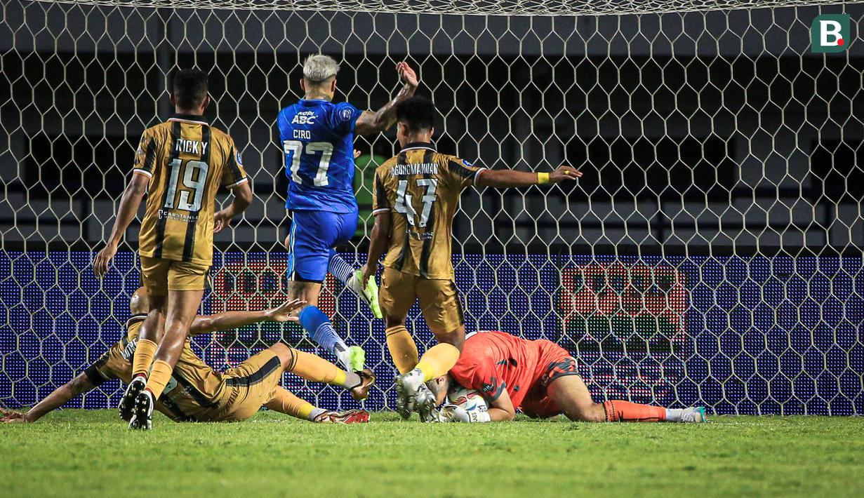 Kiper Dewa United, Sonny Stevens (kanan) berusaha menghalau bola tendangan pemain Persib Bandung, Ciro Alves pada laga pekan ketiga BRI Liga 1 2023/2024 antara Persib Bandung melawan Dewa United di Stadion GBLA, Bandung, Jumat (14/07/2023). (Bola.com/Bagaskara Lazuardi)