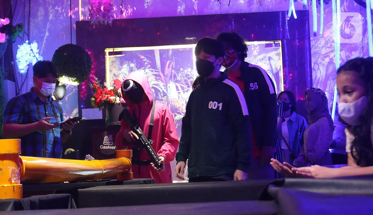 Pengunjung bermain salah satu permainan dalam serial Netflix Squid Game di Cafe Strawberry, Jakarta, Sabtu (16/10/2021). Cafe tersebut mengusung tema permainan film Squid Game untuk memberikan daya tarik bagi pengunjung yang ingin makan sekaligus mencoba permainan itu. (Liputan6.com/Herman Zakharia)