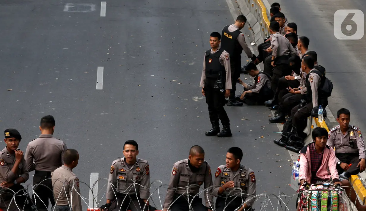 Polisi menjaga akses jalan menuju Istana Negara, Jakarta, Senin (14/10/2019). Hingga sore hari, polisi masih menutup jalan dikarenakan isu adanya demo mahasiswa yang akan berlangsung hari ini. (Liputan6.com/JohanTallo)