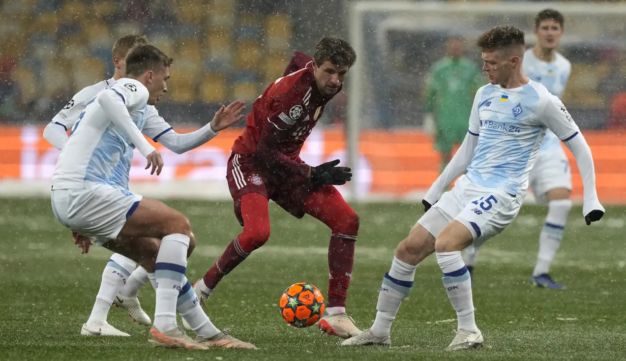 Penyerang Bayern Munchen Thomas Mueller berebut bola dengan gelandang Dynamo Kiev Viktor Tsyhankov pada matchday kelima Grup E Liga Champions di NSC Olympiyskiy, Rabu (24/11/2021). Bayern Munchen menang tipis saat bertamu ke markas Dynamo Kiev dengan skor 2-1. (AP Photo/Efrem Lukatsky)