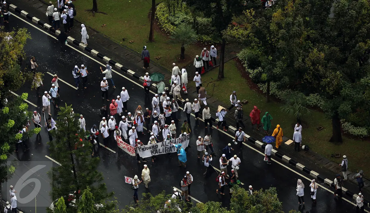 Setelah menunaikan ibadah Salat Jumat di Monas, Jakarta, massa aksi 2 Desember mulai membubarkan diri dengan tertib, Jumat (2/12). Massa yang bergerak pulang terus mengumandangkan salawat sambil mengibarkan panji-panji mereka. (Liputan6.com/Johan Tallo)