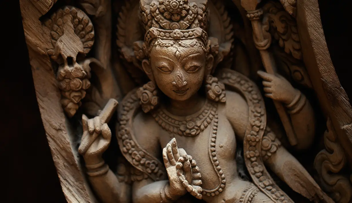 Tampilan kayu yang sebelumnya rusak akibat gempa Nepal diukir menjadi kerajainan kayu yang cantik di Lalitput, Nepal (19/7). (AP Photo/Niranjan Shrestha)