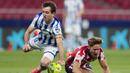 Gelandang Real Sociedad, Mikel Oyarzabal (kiri) dan gelandang Atletico Madrid, Marcos Llorente terjatuh saat perebutan bola dalam laga lanjutan Liga Spanyol 2020/2021 pekan ke-36 di Wanda Metropolitano Stadium, Rabu (12/5/2021). Atletico menang 2-1 atas Sociedad. (AP/Bernat Armangue)