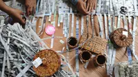 Sejumlah ibu membuat kerajinan tangan dari koran bekas di Kampung Sirnasari, Tanah Baru, Bogor, Rabu (13/2). Industri rumahan tersebut mampu menyumbangkan pendapatan hingga Rp 1,5 juta/bulan bagi setiap keluarga. (Merdeka.com/Arie Basuki)