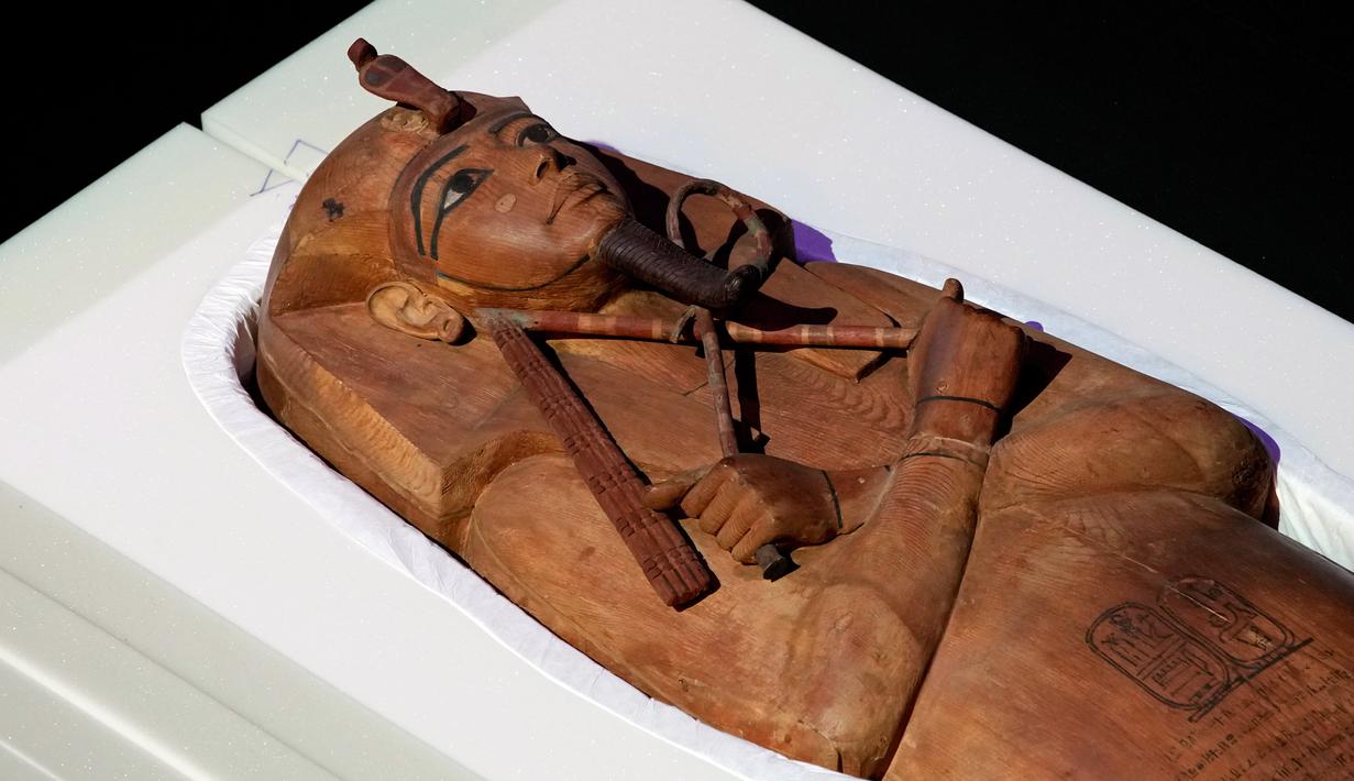 Ukiran di sarkofagus tersebut menggambarkan raja yang sedang berbaring dengan tangan bersilang di dada sambil memegang tongkat dan cambuk jabatannya. Matanya digariskan dalam warna hitam dan memakai hiasan kepala firaun bergaris serta janggut palsu yang dikepang. (AP Photo/Christophe Ena)
