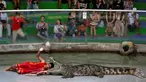 Seorang pria beratraksi dengan meletakkan kepalanya kedalam mulut buaya di Sriracha Tiger Zoo, Provinsi Chonburi , Thailand , 7 Juni 2016. Aksi nekat ini mengundang decak kagum wisatawan yang hadir. (REUTERS / Chaiwat Subprasom)