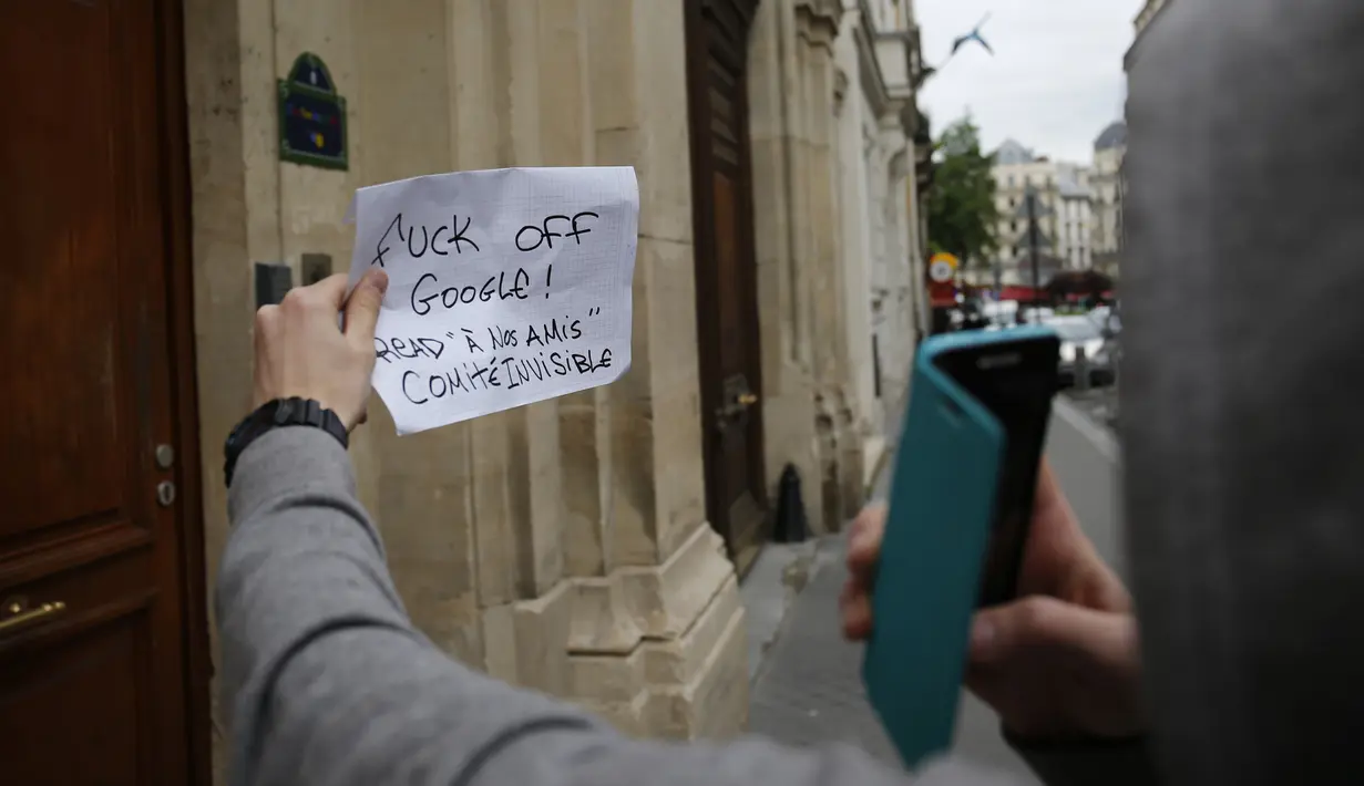 Seorang wanita berdiri sambil memegang kertas di depan kantor Google di Paris, Selasa (24/5). Pejabat keuangan Prancis melakukan penggerebekan kantor raksasa internet Google sebagai bagian dari penyelidikan penggelapan pajak. (MATTHIEU ALEXANDRE/AFP)