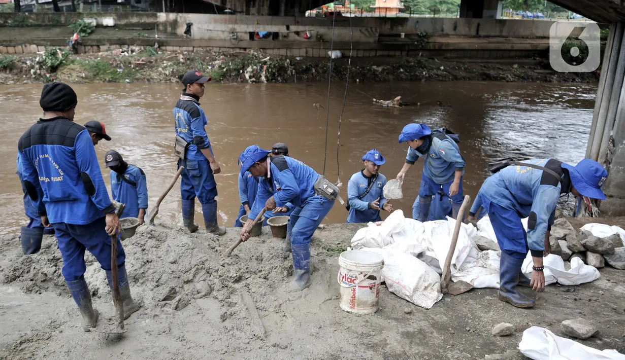 Pekerja Sudin Sumber Daya Air Jakpus menyelesaikan penutupan lubang rembesan di Tanggul Kanal Banjir Barat, Latuharhari, Minggu (5/1/2020). Penutupan untuk mengantisipasi tanggul jebol setelah diketahui terdapat rembesan di sejumlah titik akibat debit air KBB meningkat. (merdeka.com/Iqbal Nugroho)