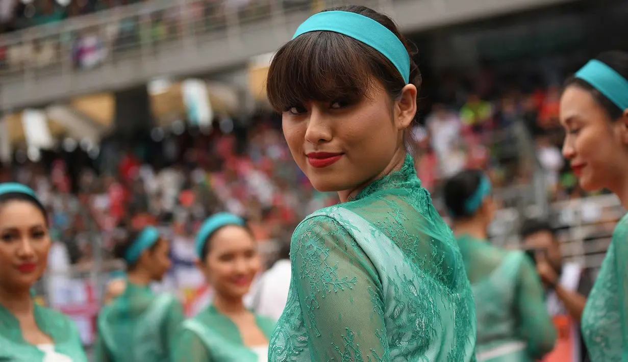 Seorang gadis payung atau grid girl berpose sebelum dimulainya Grand Prix Formula 1 Malaysia di Sepang (1/10). Para gadis payung ini terlihat cantik dan seksi dengan busana yang dikenakannnya. (AFP Photo/Manan Vatsyayana)