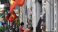 Umat Buddha berdoa di luar pagoda Cau Dong saat perayaan Hari Waisak di Hanoi, Vietnam pada Rabu (26/5/2021). Tempat ibadah di kawasan tersebut ditutup untuk mencegah penyebaran virus corona Covid-19. (Nhac NGUYEN / AFP)