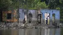 Warga memancing diantara puing bangunan rumah yang kembali muncul di kawasan Bendungan Karian yang mengering di Kampung Somang, Lebak, Banten, Kamis (30/7/2026). (AFP/ Bay Ismoyo)